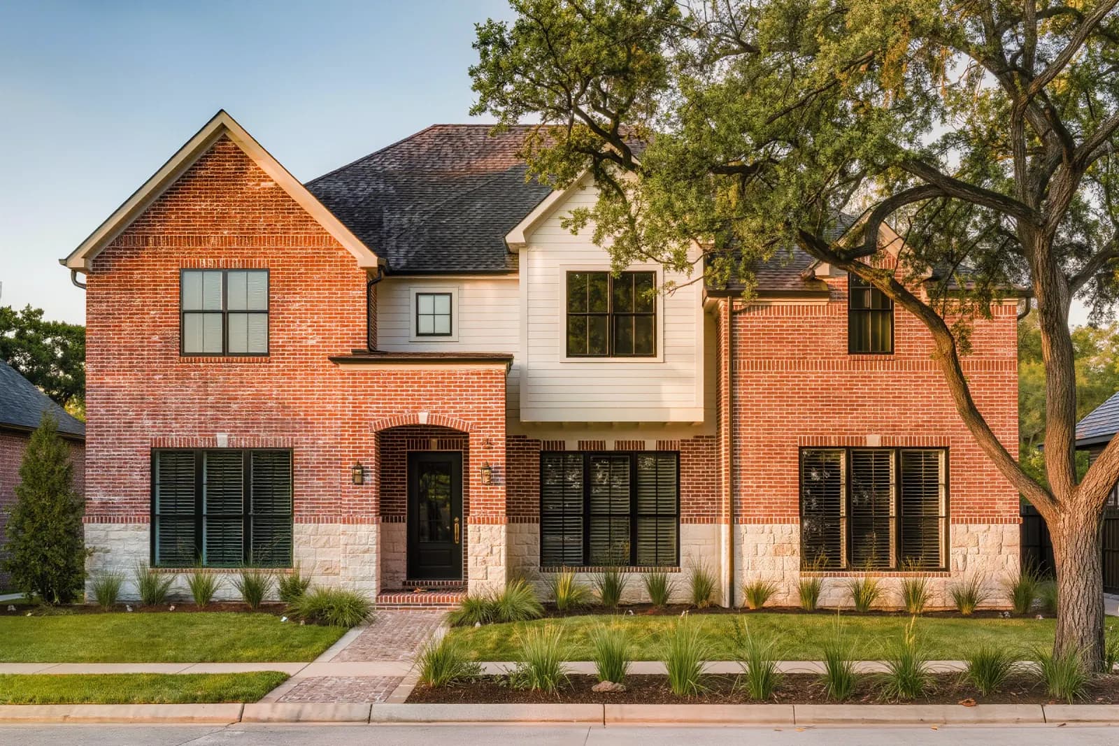 Two-story home with a deep front porch on a tree-lined Plum Creek street in Kyle, Texas