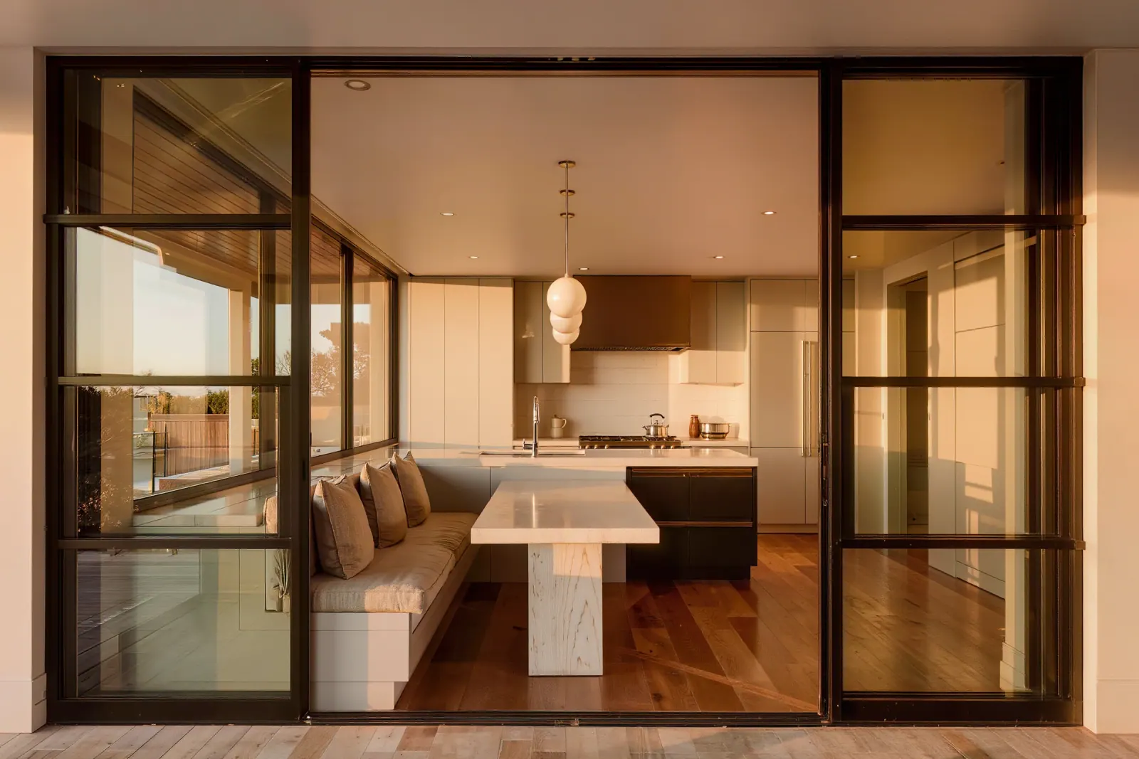 Breakfast nook with a built-in banquette and black steel doors opening to a covered patio