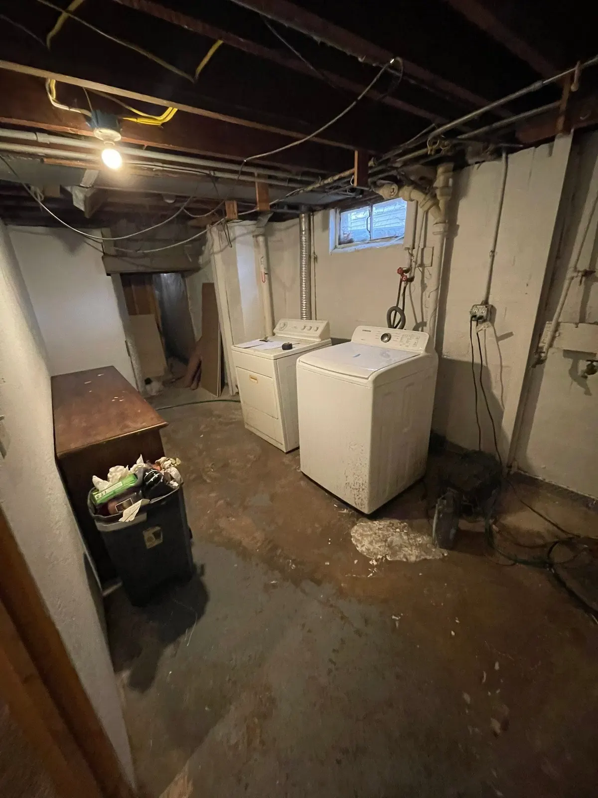 Before: the basement from the stair with ductwork and block walls exposed