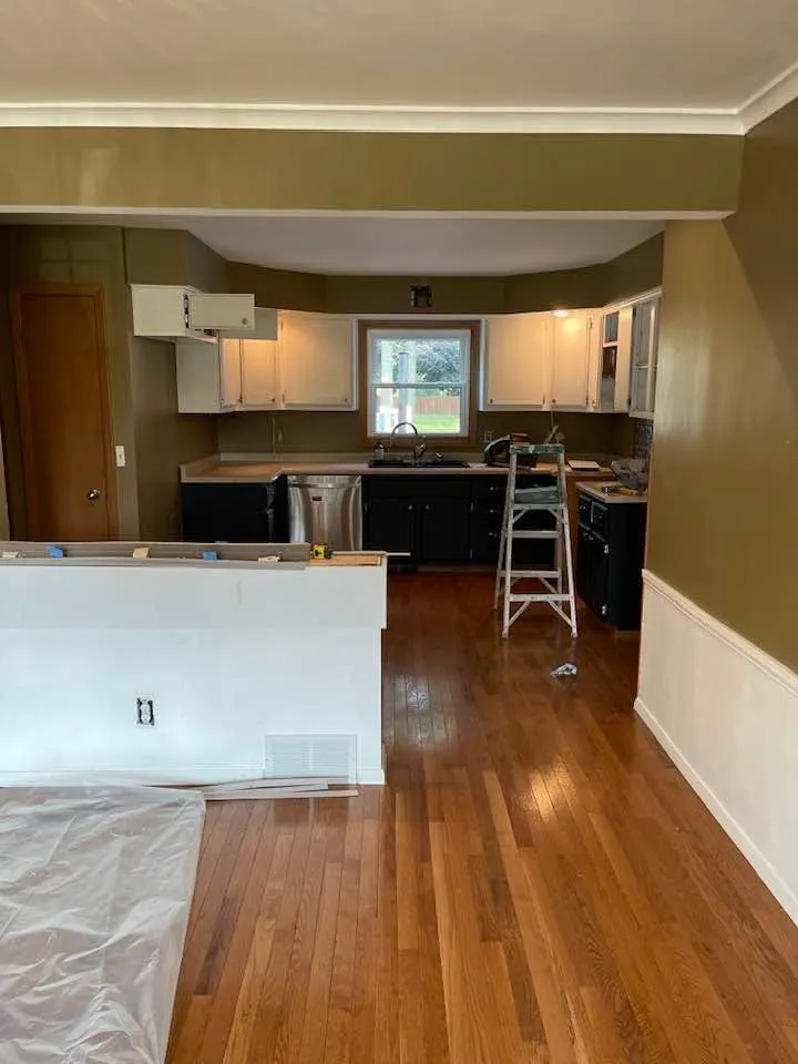Before: the same kitchen from the dining side, showing the peninsula and half-wall that closed it off