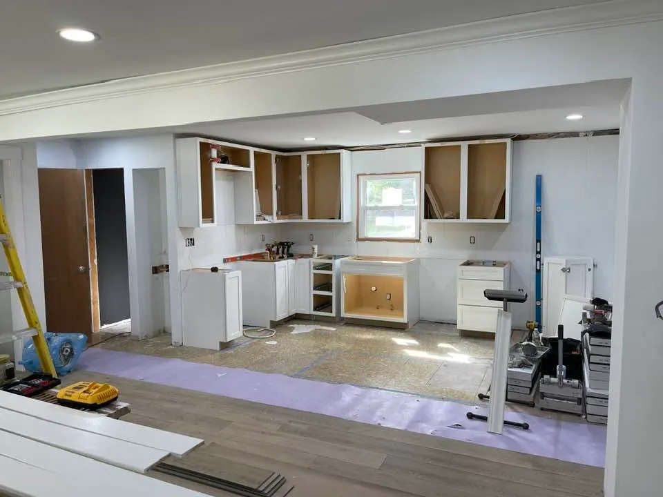 New cabinet boxes set on the back wall, counters not yet installed