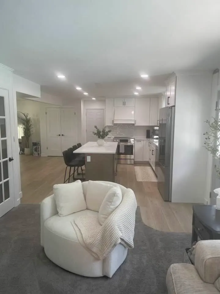 After: the living area with a cream sofa, connected to the kitchen