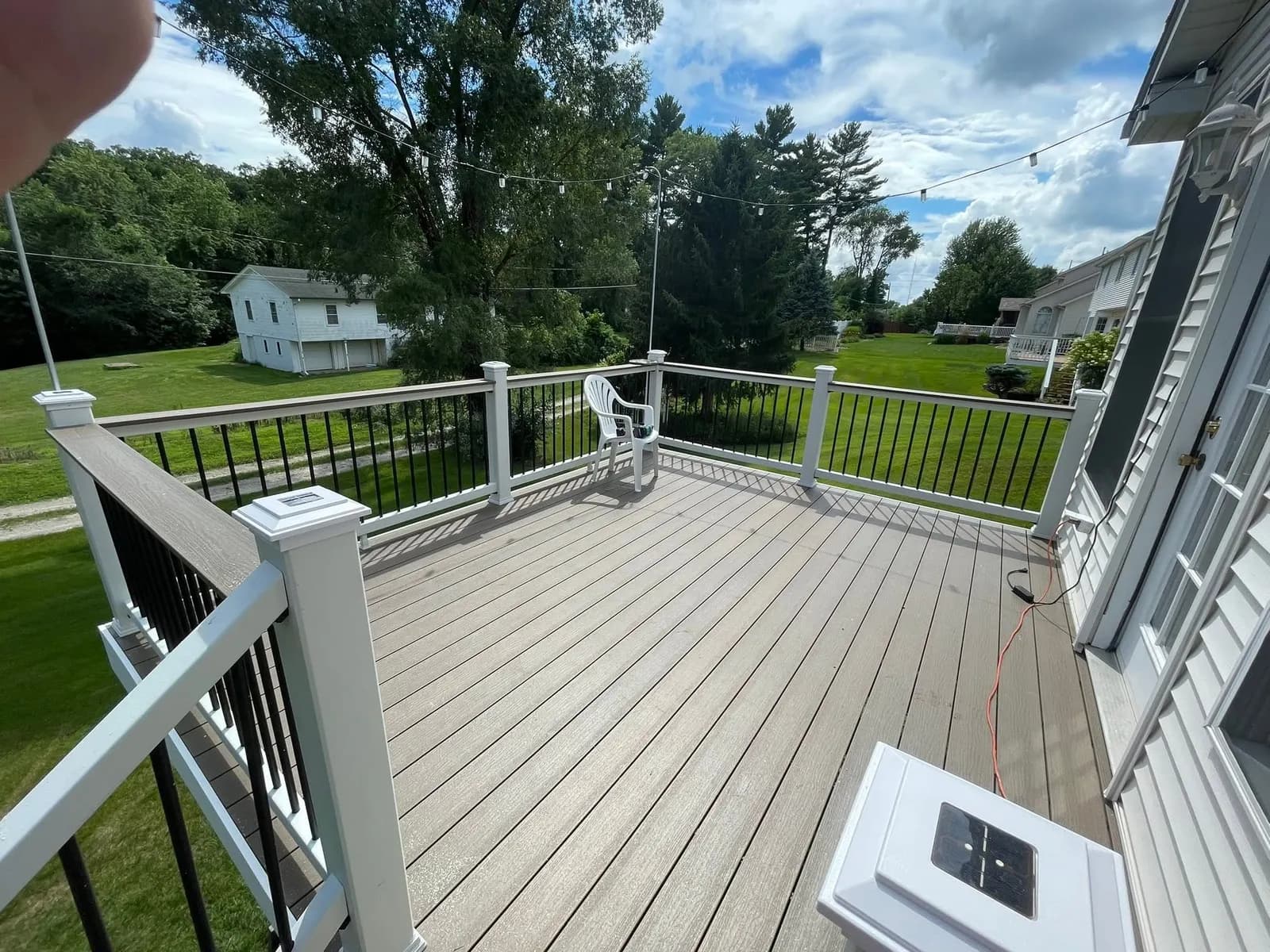 After: the composite deck surface with black aluminum balusters and a view over the lawn