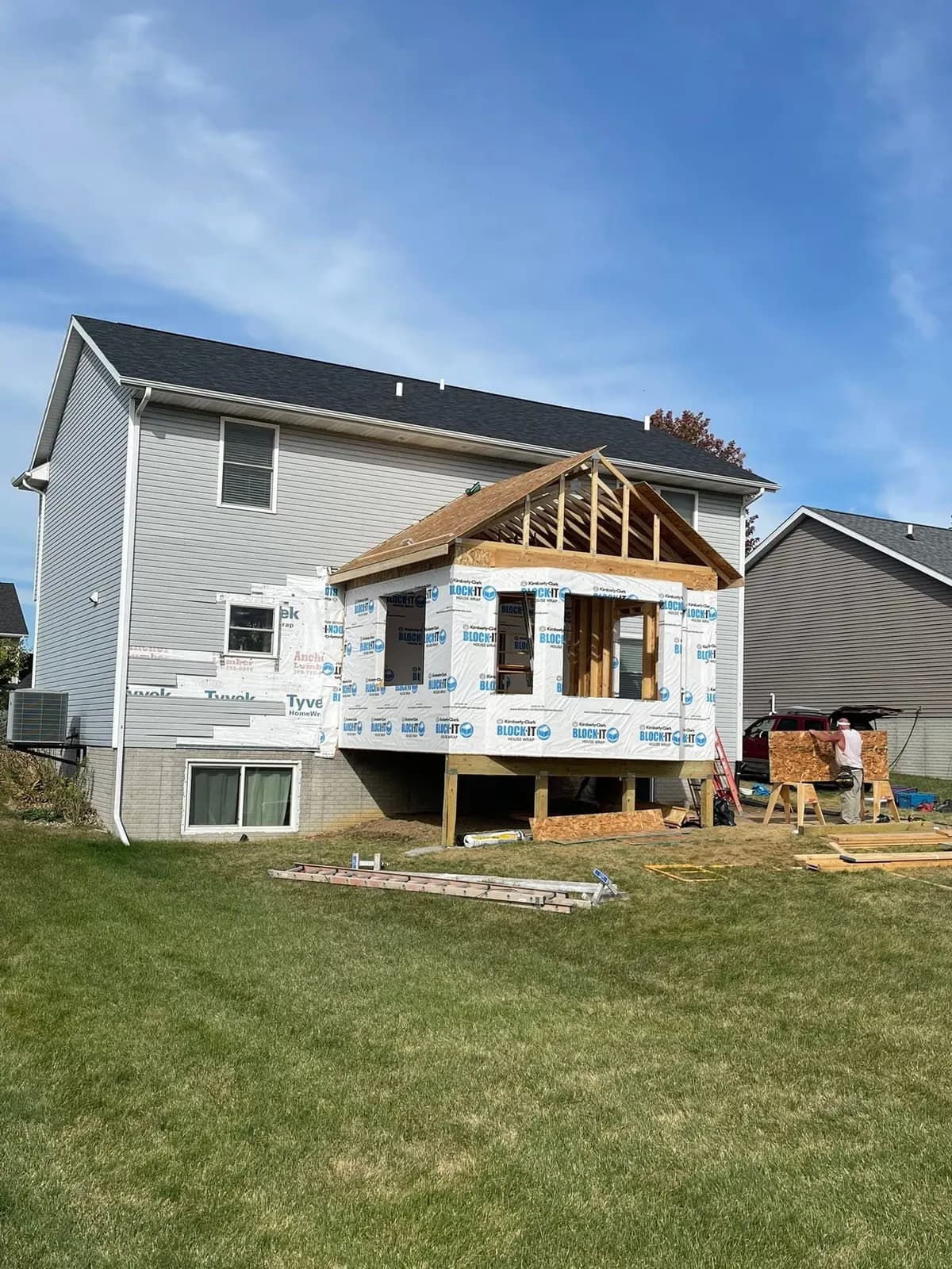The framed addition from the yard, roof trusses in place against the existing house