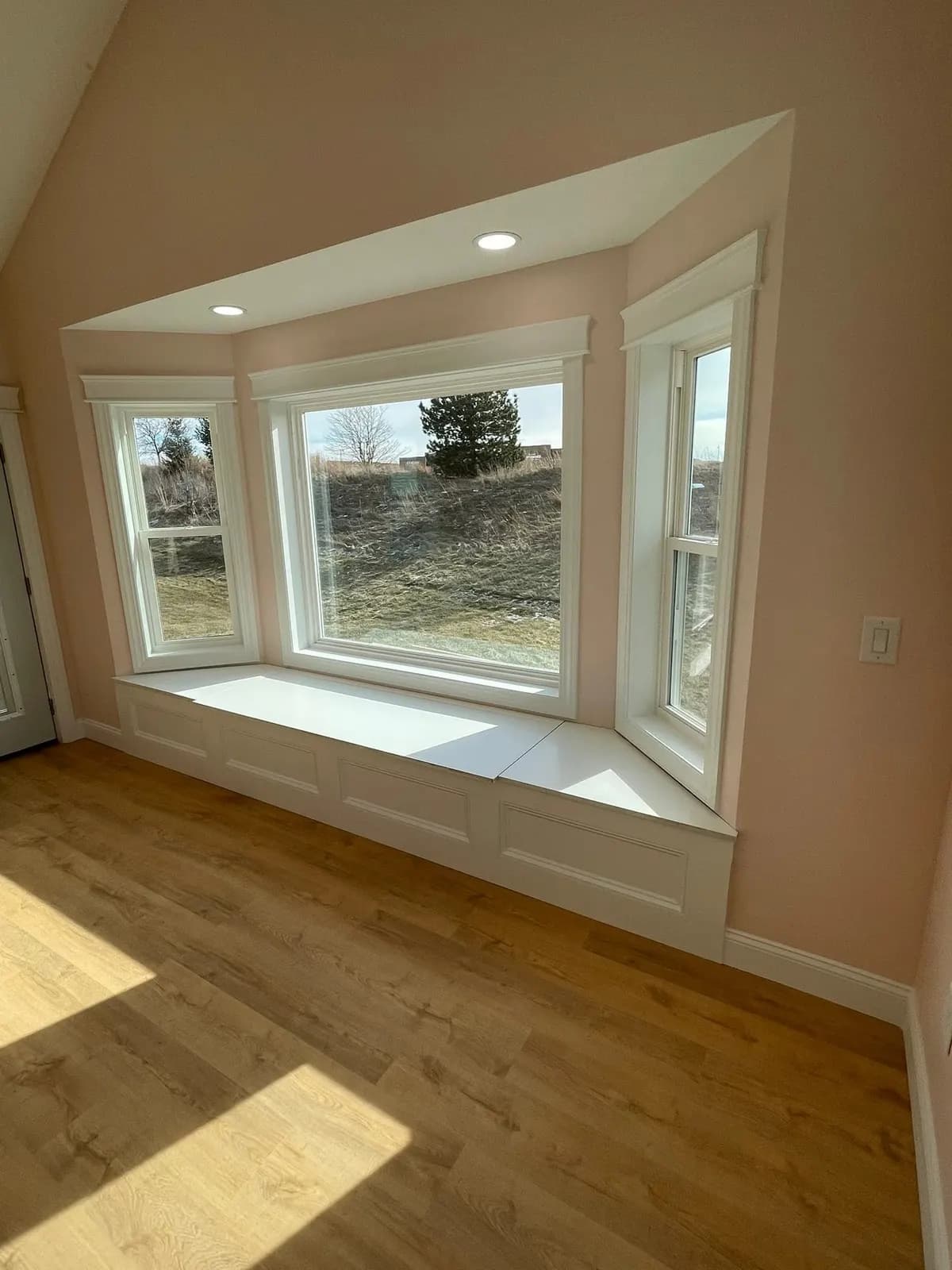 After: the bay window seat with white trim and views over the field
