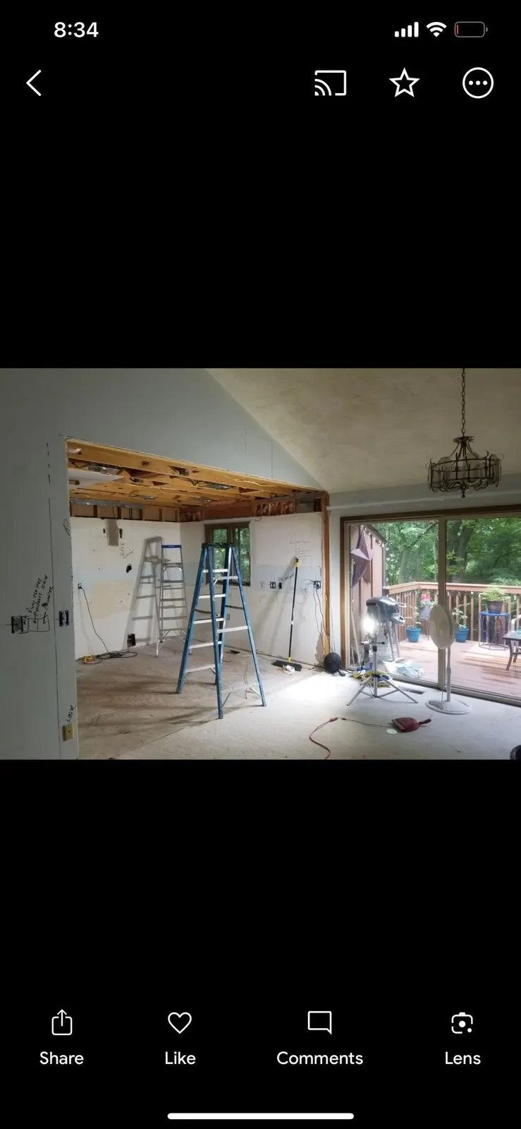 Before: the load-bearing wall opened with a temporary header, ladders set, and the old chandelier still hanging