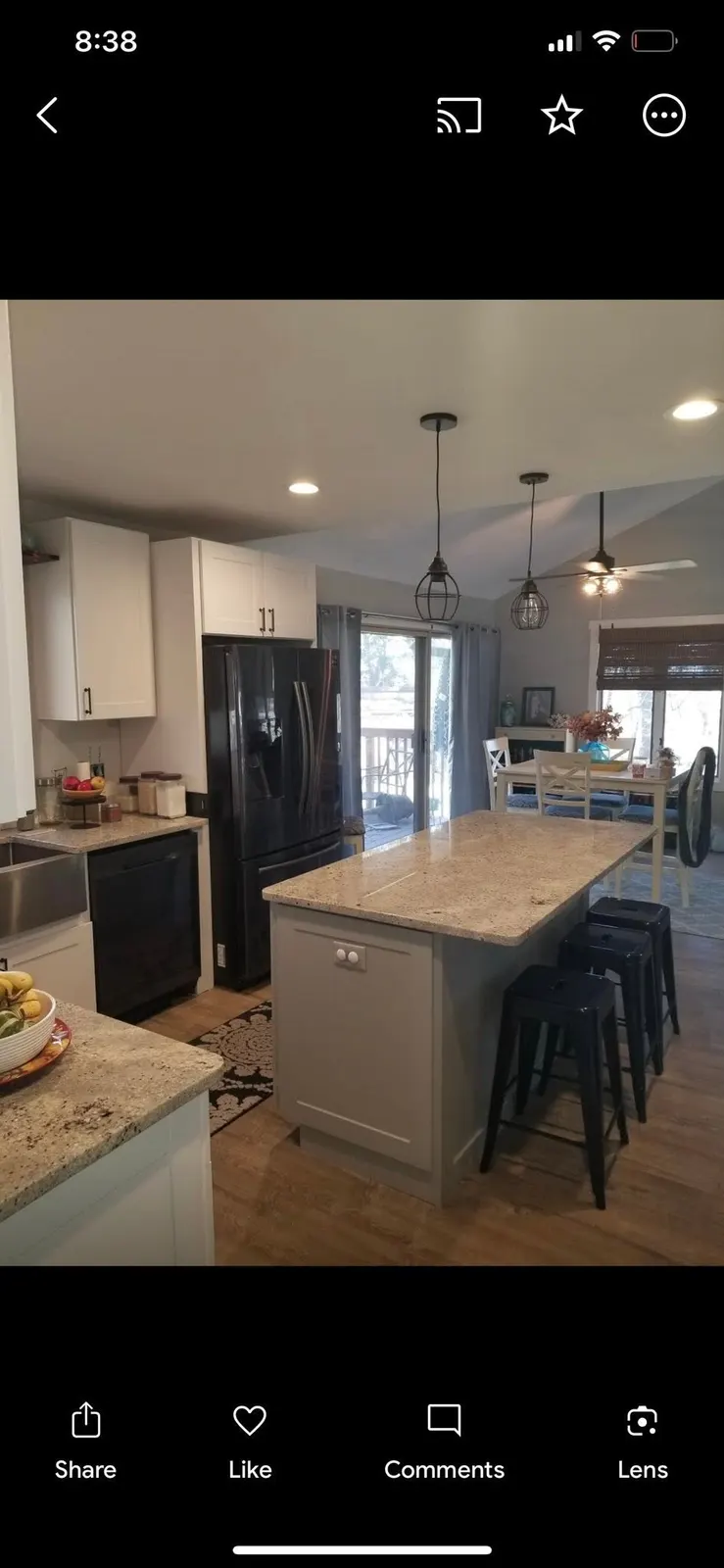 After: the island and sink wall with black appliances and a view to the deck
