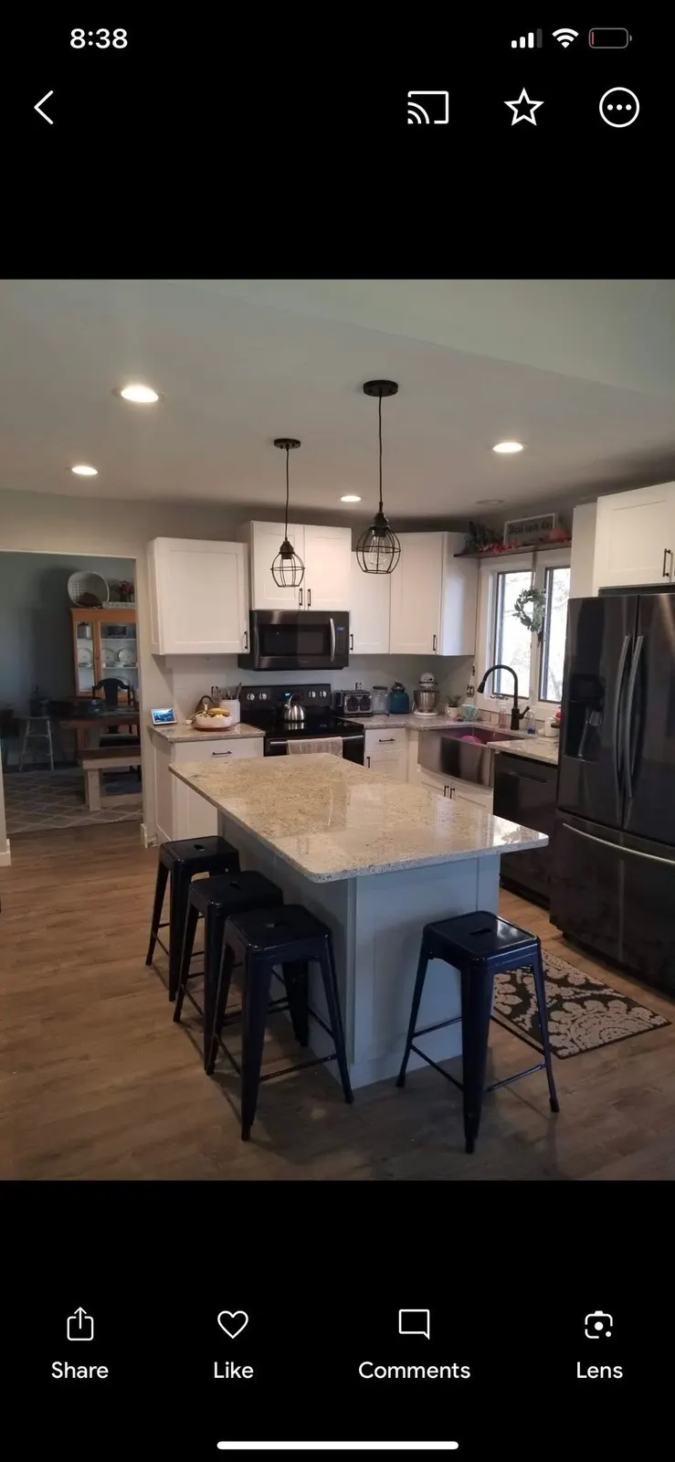 After: the full kitchen with island, stools, and the opened wall to the living room