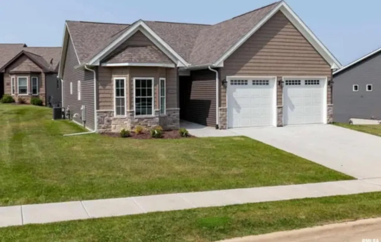 Front of a finished two-story home with stone accents and a two-car garage